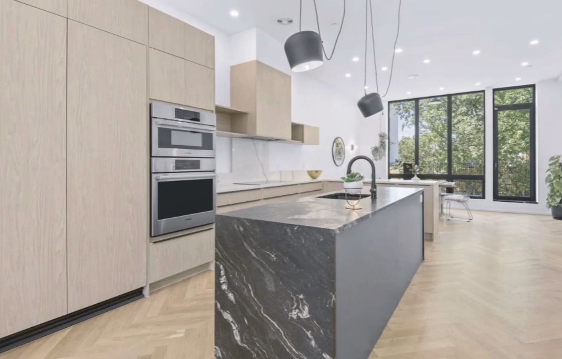 Contemporary kitchen featuring European frameless light wood cabinets and a large dark marble island by Modernform Cabinets and Closets in Carrollton, Texas.