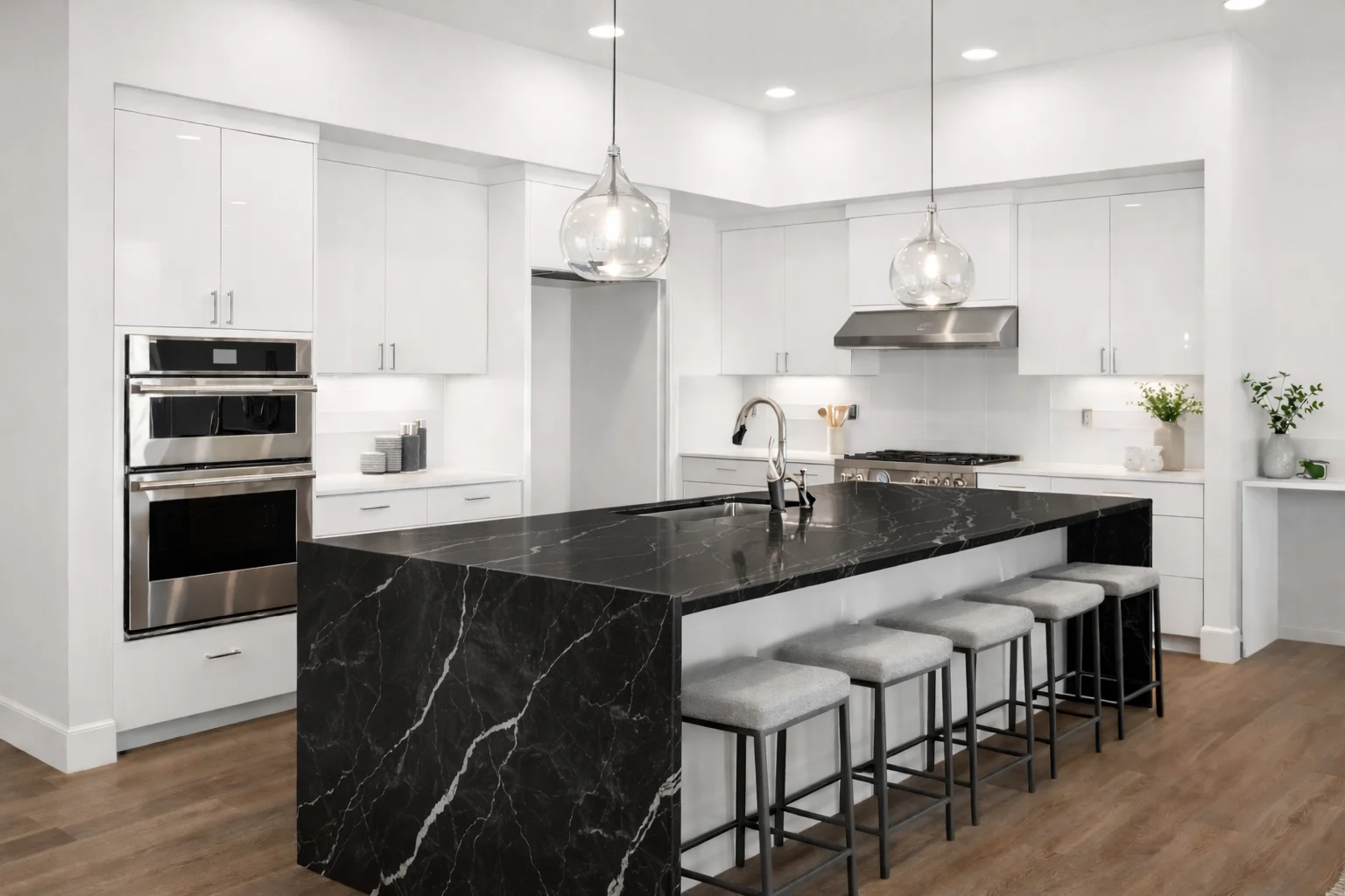Bright modern kitchen featuring custom glossy white flat-panel cabinets, dark countertops, and a contrasting dark island.