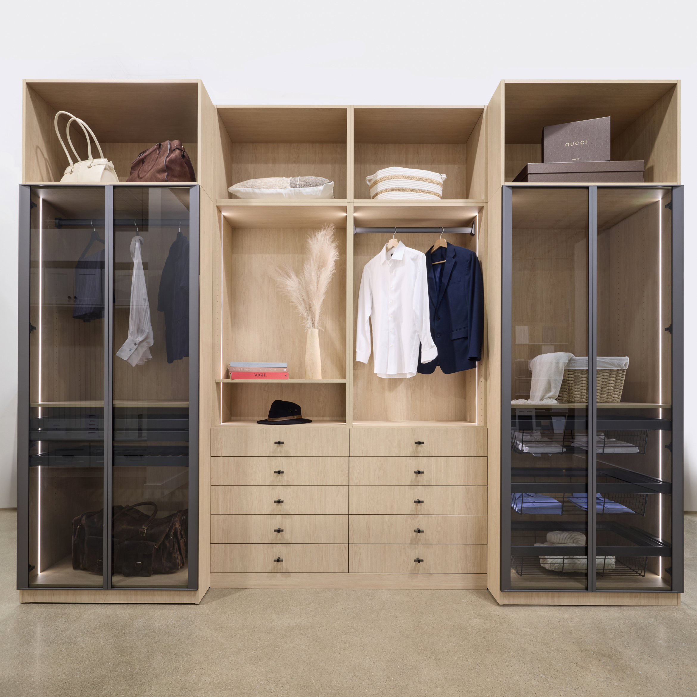 Custom light wood closet organization system showcasing the built-in drawer configurations, open shelving, and hanging sections prior to being filled.