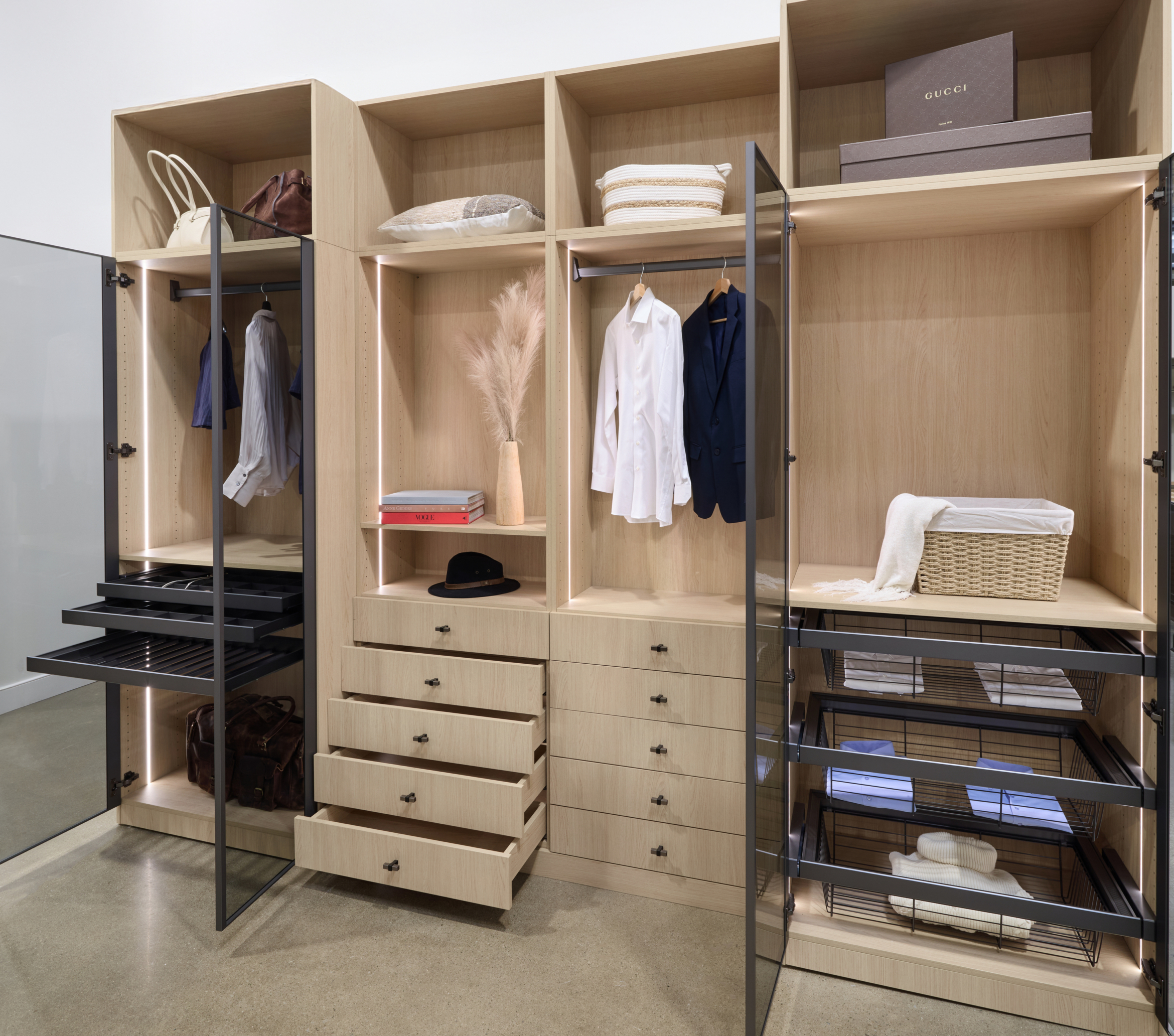 Custom walk-in closet featuring a warm wood organization system with integrated drawers, open shelving, and hanging storage.