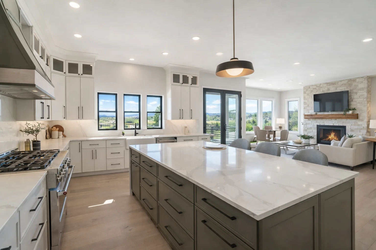 Bright modern kitchen featuring custom slim dove white shaker cabinets, a large center island with seating, and glass pendant lights.
