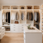 Wholesale white custom walk-in closet system with open shelving, hanging space, and integrated lighting.