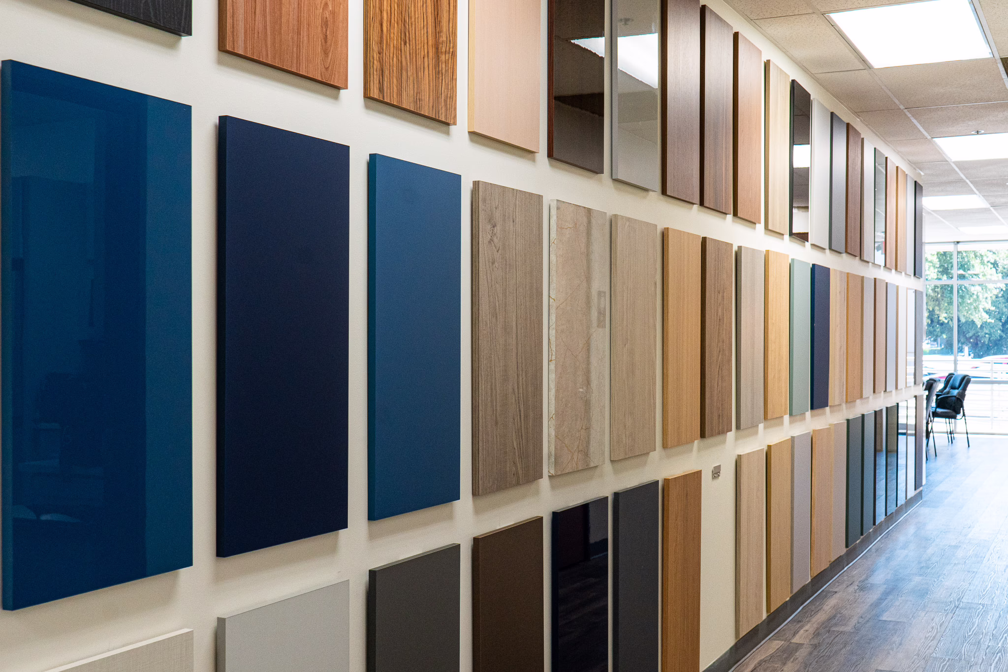 Wall display showing cabinet door styles and color finish swatches at the Modernform Cabinets and Closets showroom in Carrollton Texas