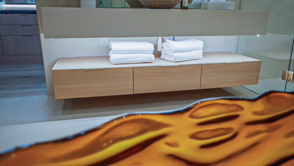 Natural oak European frameless floating bathroom vanity featuring long handleless wood drawers and an integrated light stone sink vanity top with folded white towels.